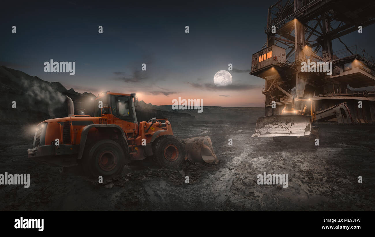 Heavy equipment vehicles of various types - wheeled bulldozer -  in night shift work on a construction site at open pit mine. Stock Photo