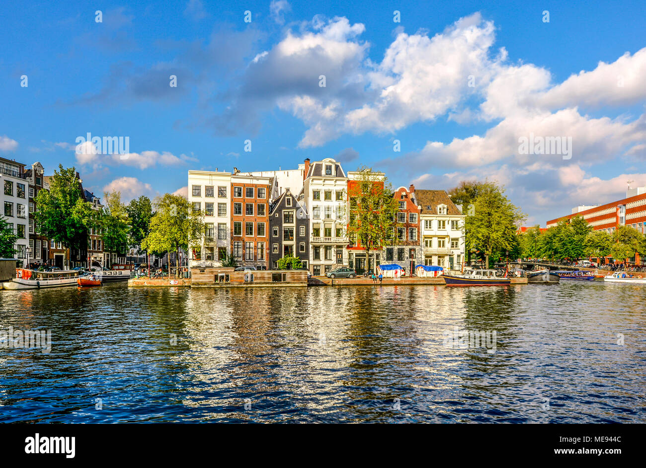 A row of canal homes stacked together tightly on a canal in the museum district of Amsterdam, The Netherlands Stock Photo