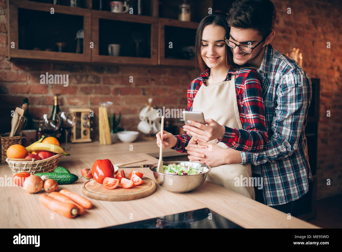 Happy love couple prepares romantic dinner on the kitchen. Smiling ...