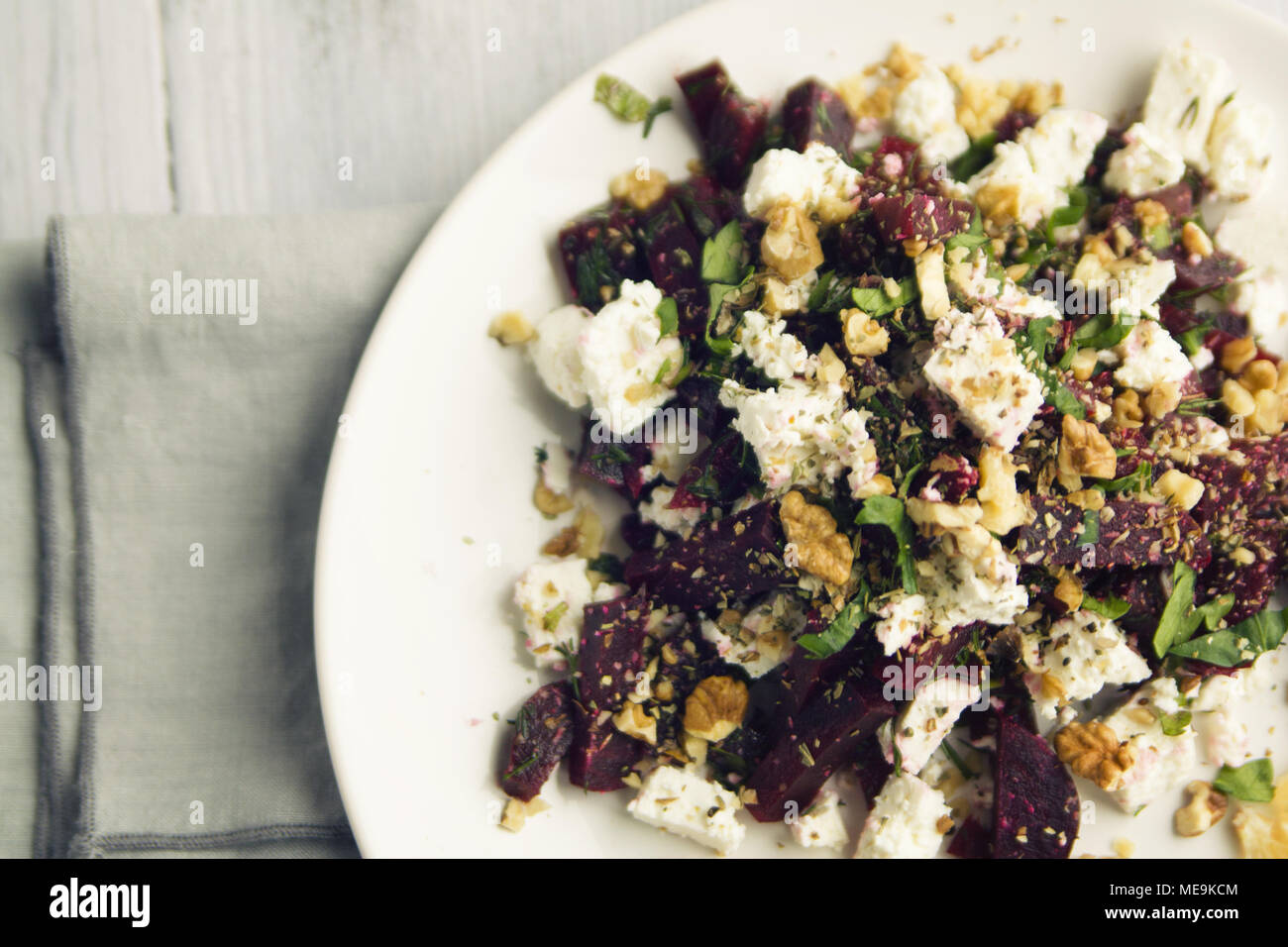 Beetroot salad with cottage cheese and walnuts. European cuisine. Top view. Vegetarian appetizer. Simple side dish. Toned photo. Organic dish. Stock Photo