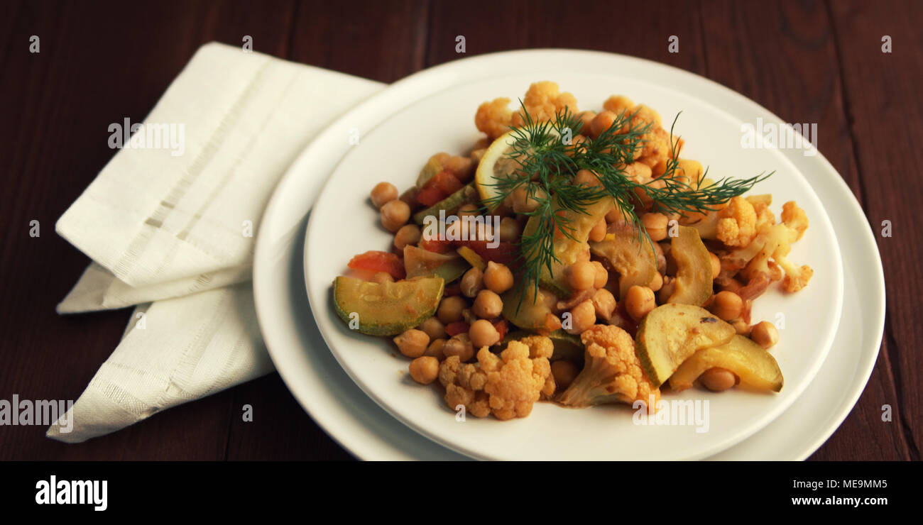 Vegetable stew with chickpeas, cauliflower and cabbages. Organic food. Vegan dish. European cuisine. Vegetarian lunch. Wide photo. Close up. Stock Photo