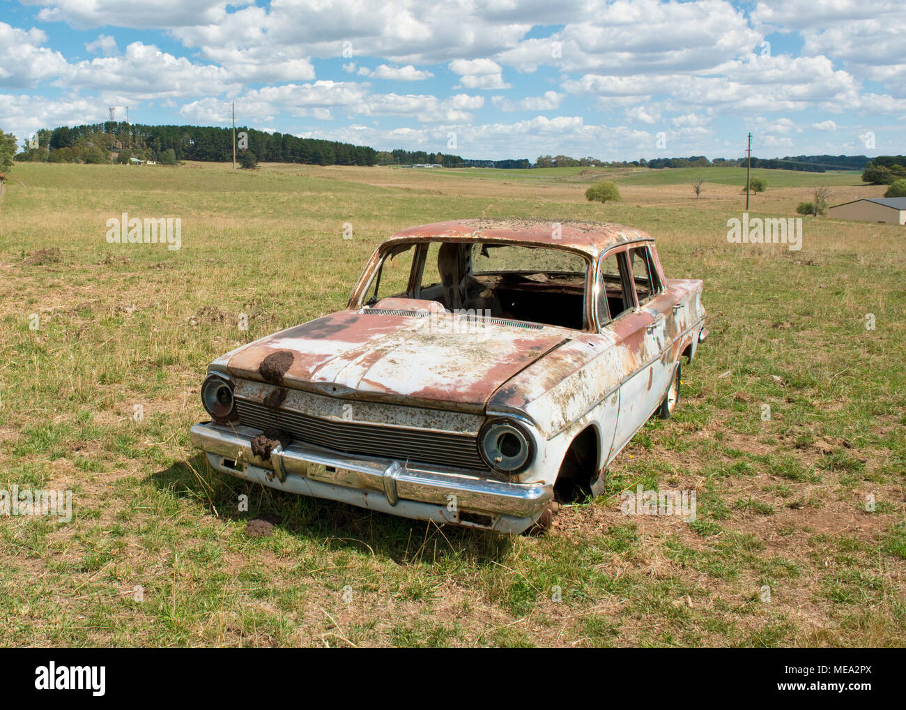 Wreck of Australian Holden car in farm field. New South Wales, Australia Stock Photo