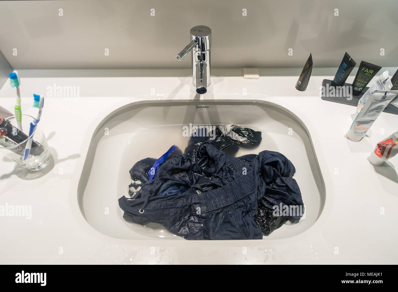 Washing laundry in a hotel sink. Stock Photo