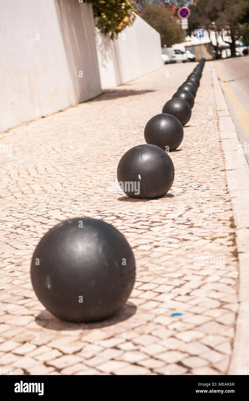Round bollards along a footpath to prevent parking. Stock Photo