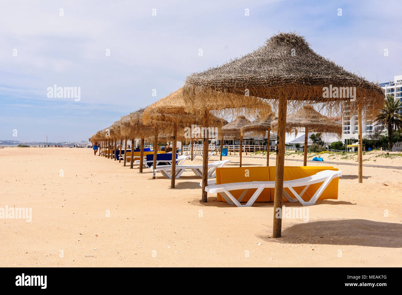 Rows of straw parasols and sunloungers on the beach at Vilamoura, Algarve, Portugal. Stock Photo