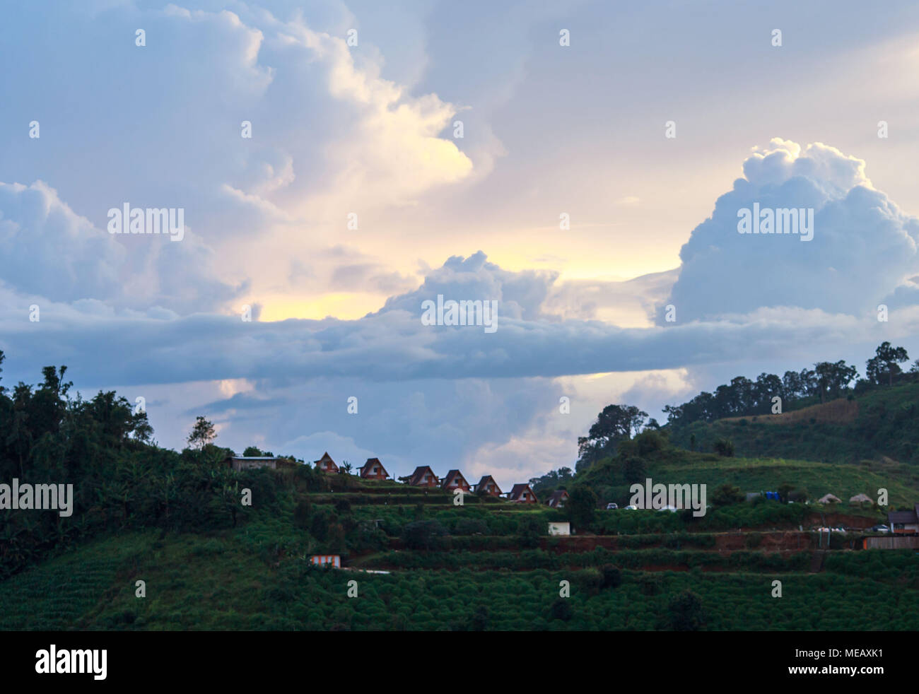 Dramatic sunset over small mountain cottages near the village of Moncham, Thailand Stock Photo