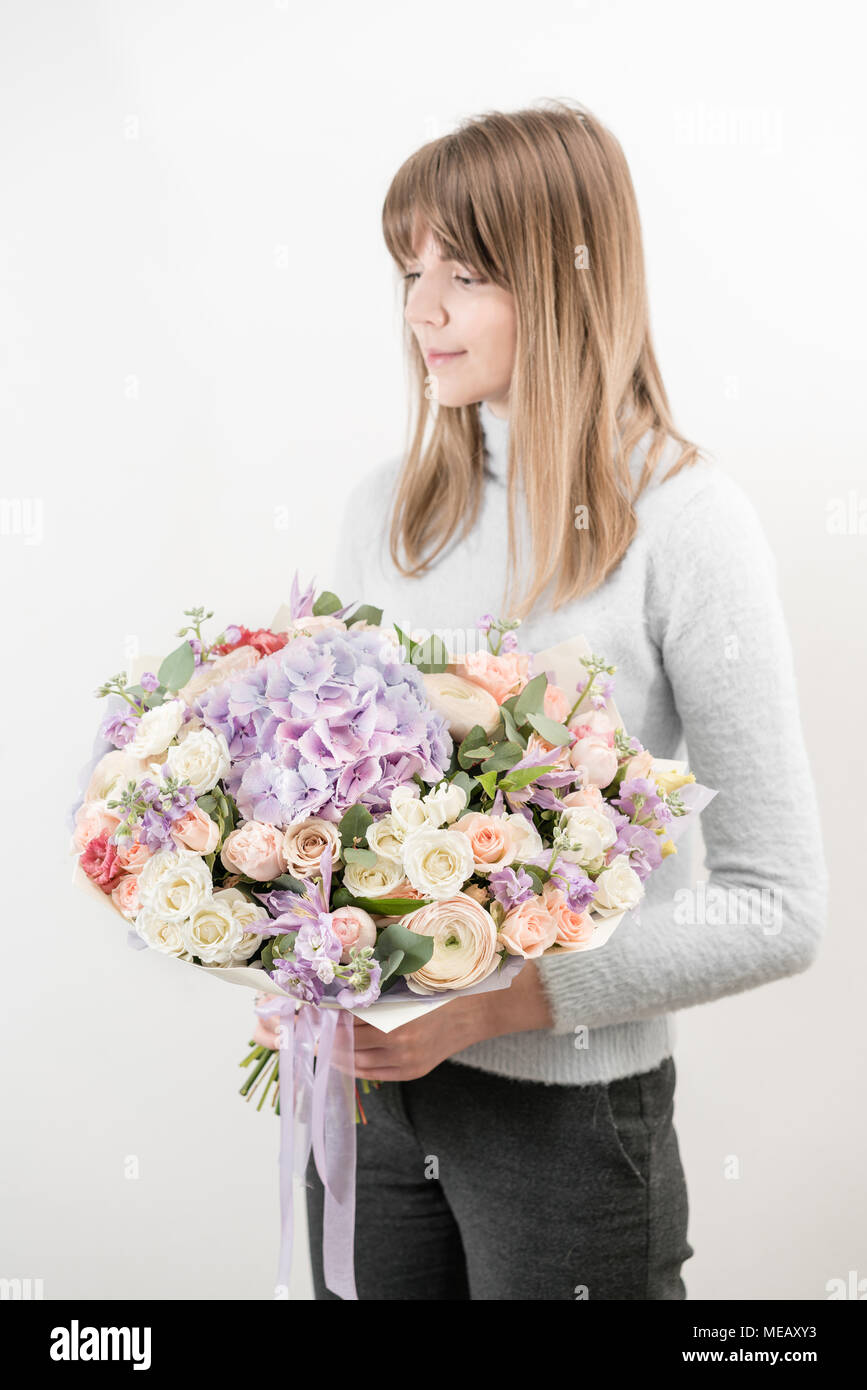 lilac and light bouquet of beautiful flowers in women's hands. Floristry concept. Spring colors. the work of the florist at a flower shop. Vertical photo Stock Photo