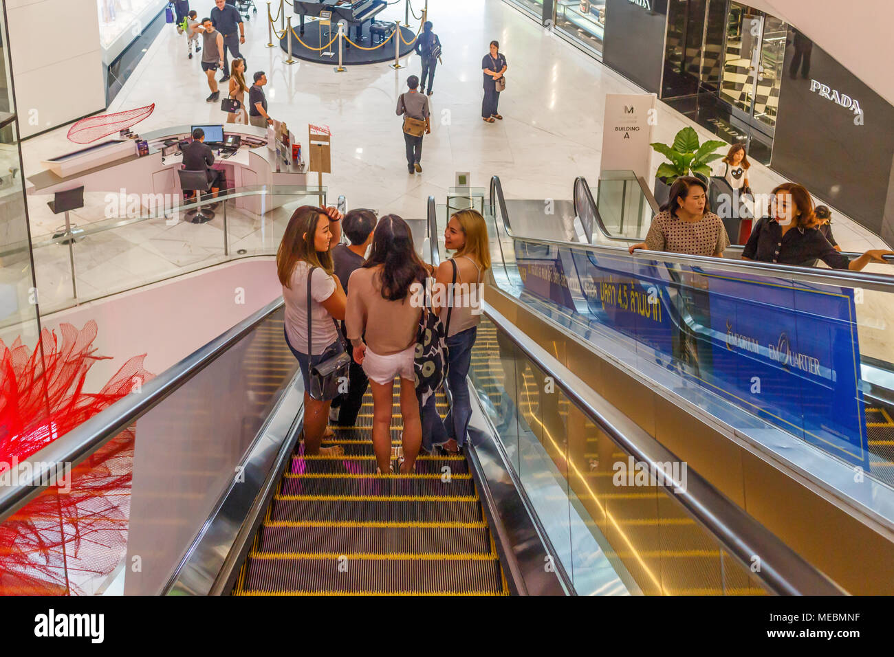 People descending and ascending escalators, Em Quartier shopping mall, Bangkok, Thailand Stock Photo