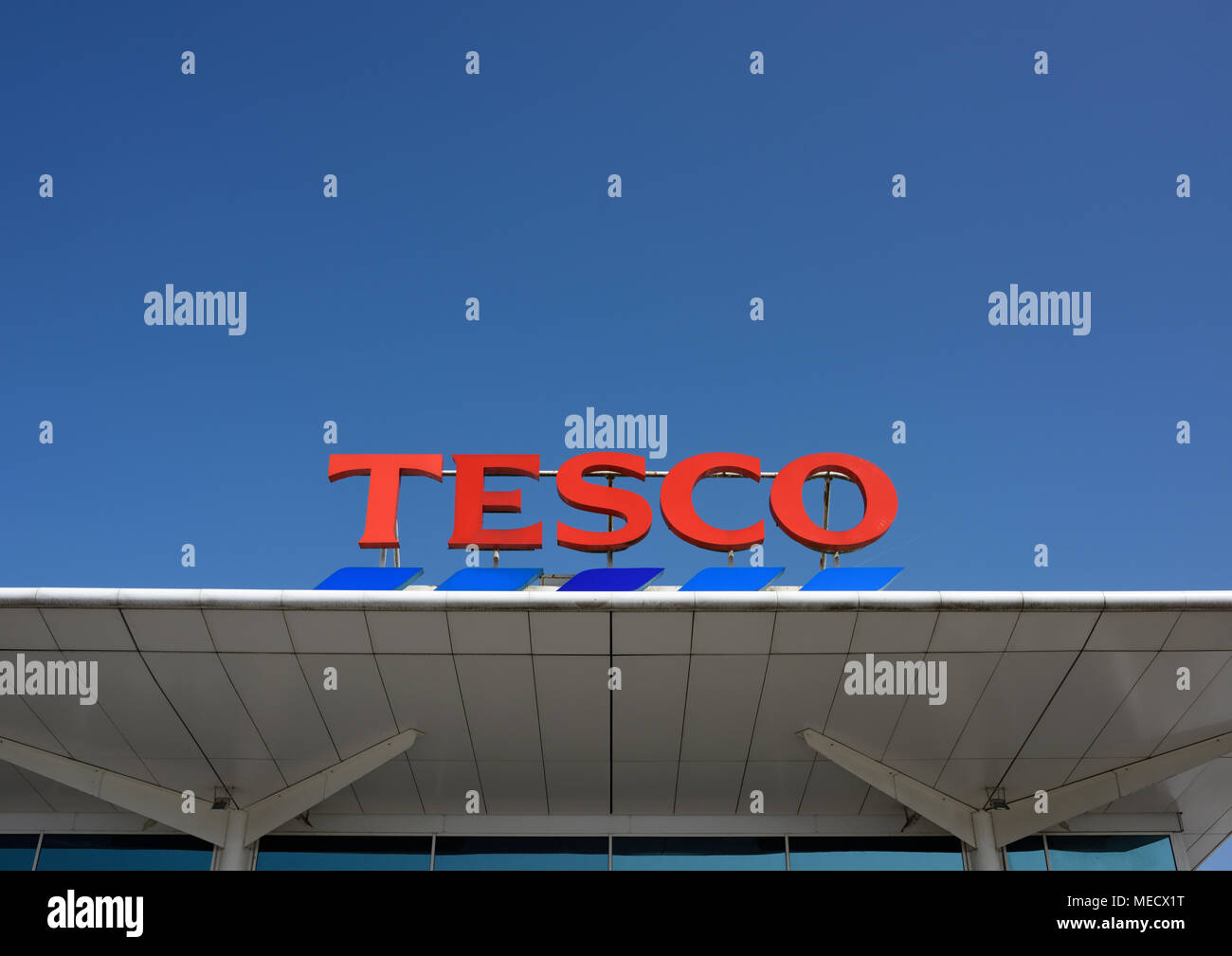 Tesco logo mounted on white roof panel on tesco store in bury