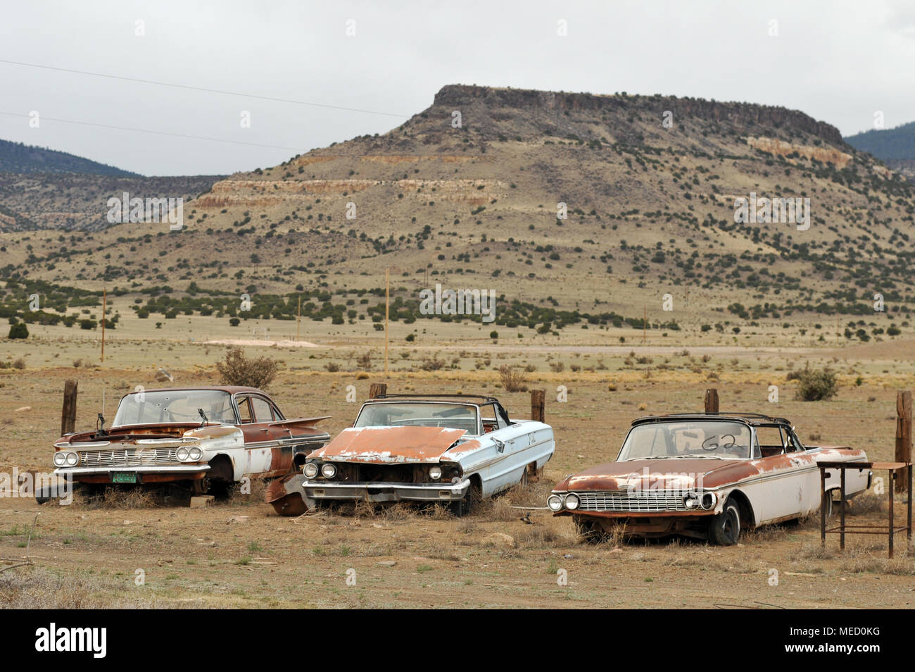 Rusting vintage cars sit in a field off old Route 66 near San Fidel, New Mexico. Stock Photo