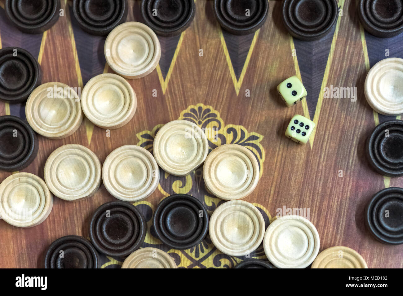 Wooden backgammon. Play a board game. The hand is throwing dice. Stock Photo