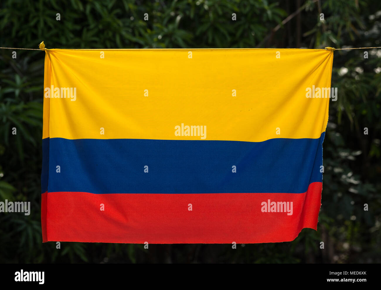 A tri-colored Colombian flag hanging on a rope. Colombia, South America. Stock Photo