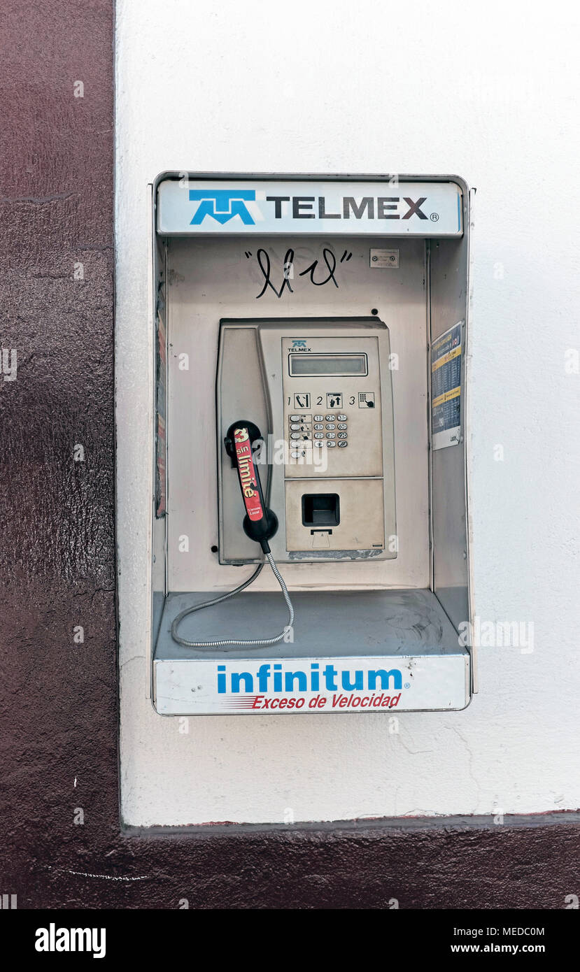A TELMEX public telephone attached to a stucco wall in Mexico City, Mexico stands unused. Stock Photo