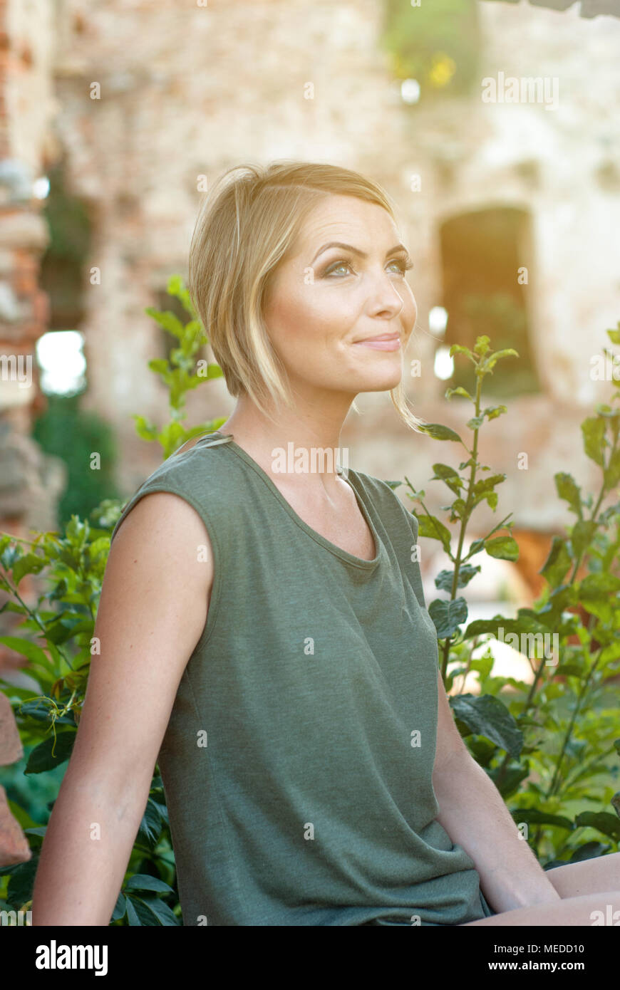 Beautiful happy blonde woman smiling and enjoying her time outside in park Stock Photo