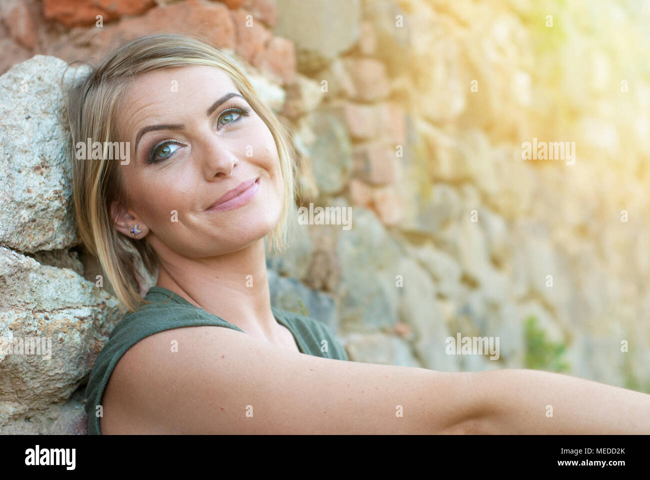 Beautiful happy blonde woman smiling and enjoying her time outside in park Stock Photo