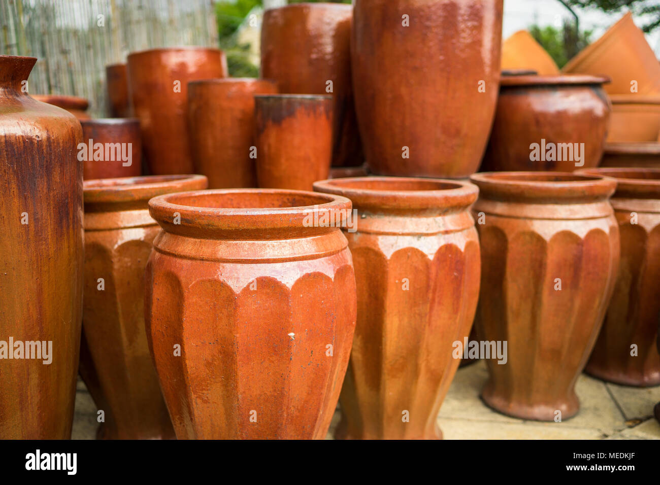 https://c8.alamy.com/comp/MEDKJF/large-orange-brown-ceramic-flower-pots-stacked-at-a-plant-nursery-MEDKJF.jpg