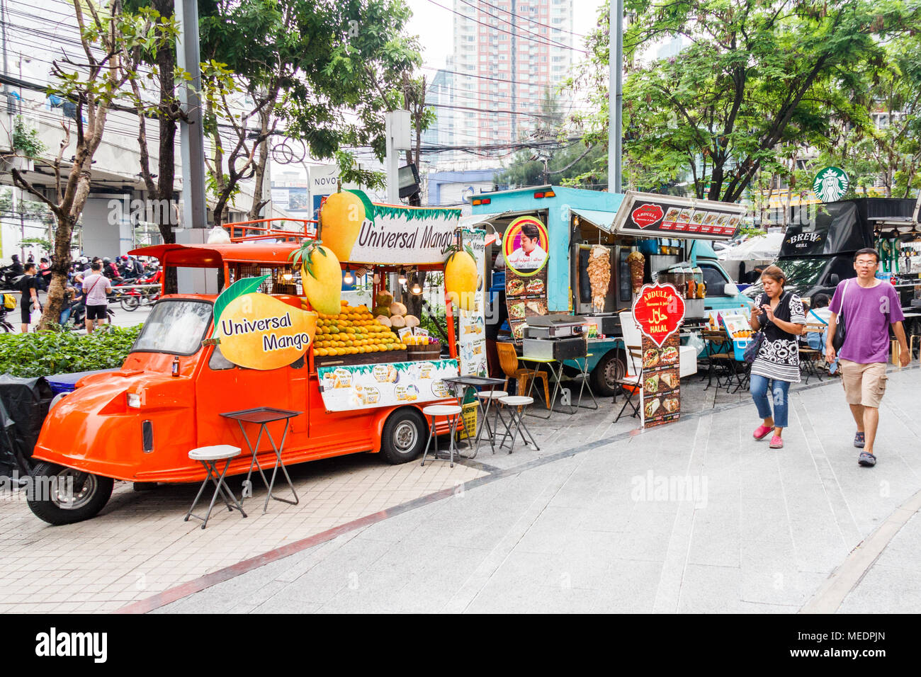 People walking past  food trucks, Bangkok, Thailand Stock Photo