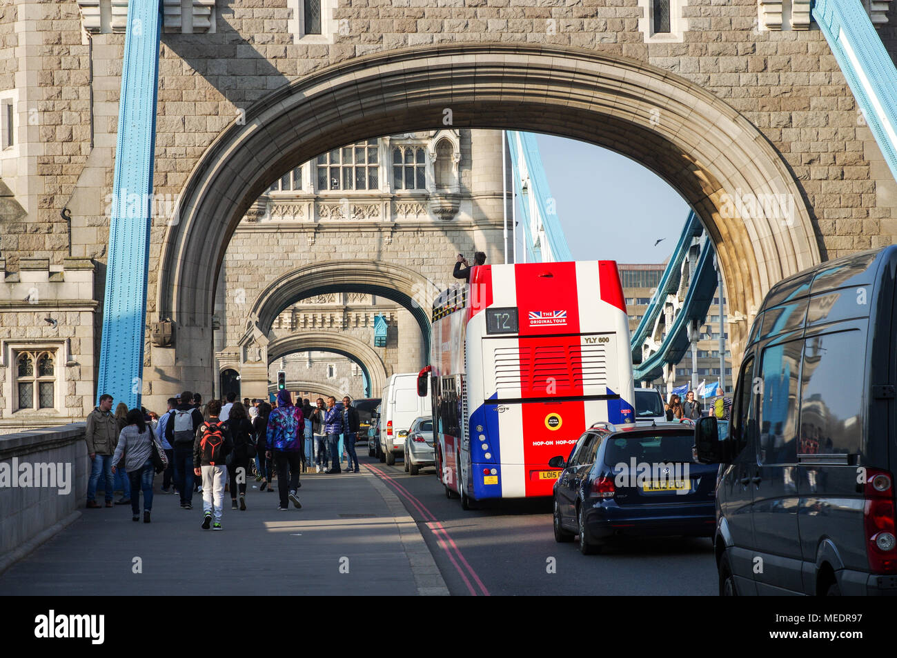 Double-decker bus painted in Union Jack colours passing under the arches of Tower Bridge in London, Great Britain Stock Photo
