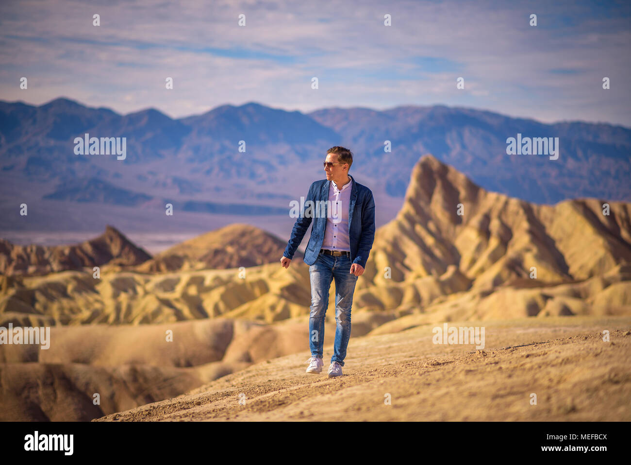 Young man walking alone in the desert of Death Valley Stock Photo