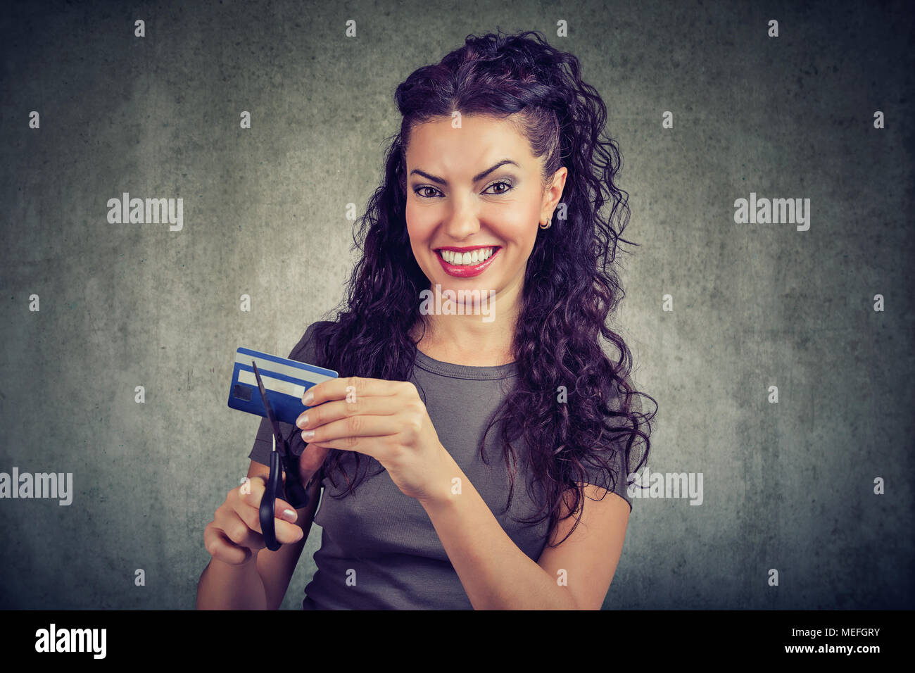 Cheerful young woman looking happily at camera done with credit cards. Stock Photo