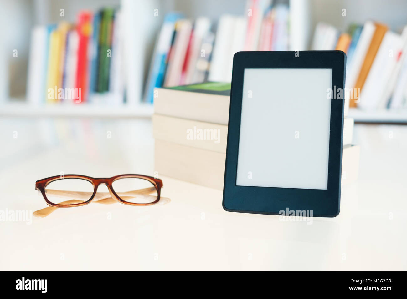 Ebook reader on bookshelf background.Copy space on digital tablet
