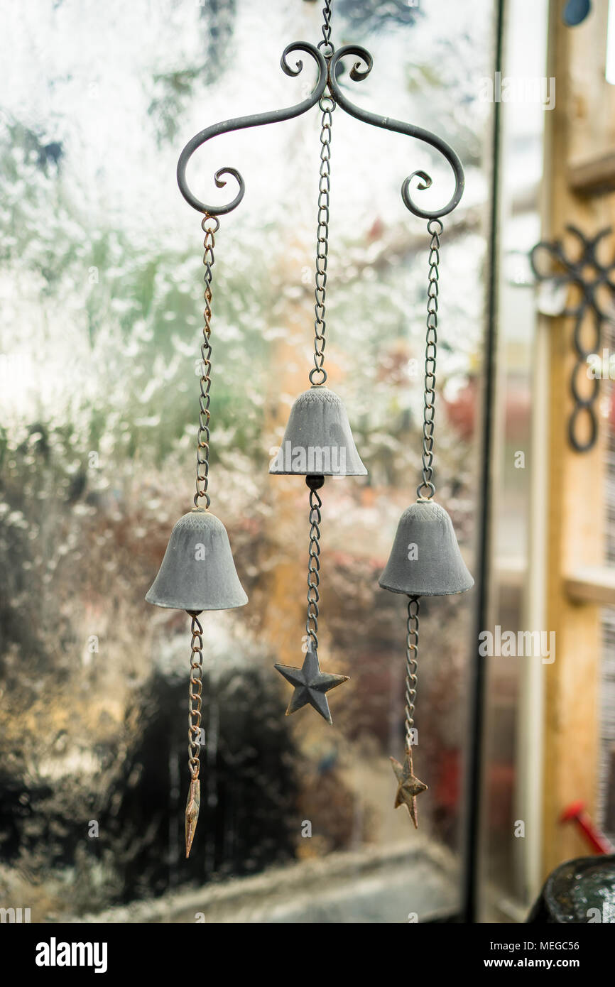 3 small bells create a hanging garden ornament in a nursery Stock Photo