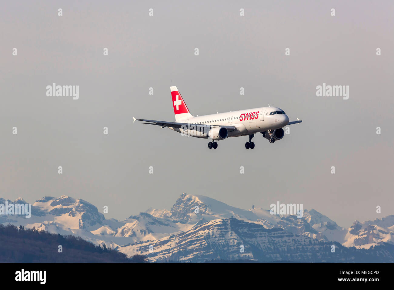 Airplane in approach on Zurich ZRH, snow covered Alps, Airline Swiss. Stock Photo