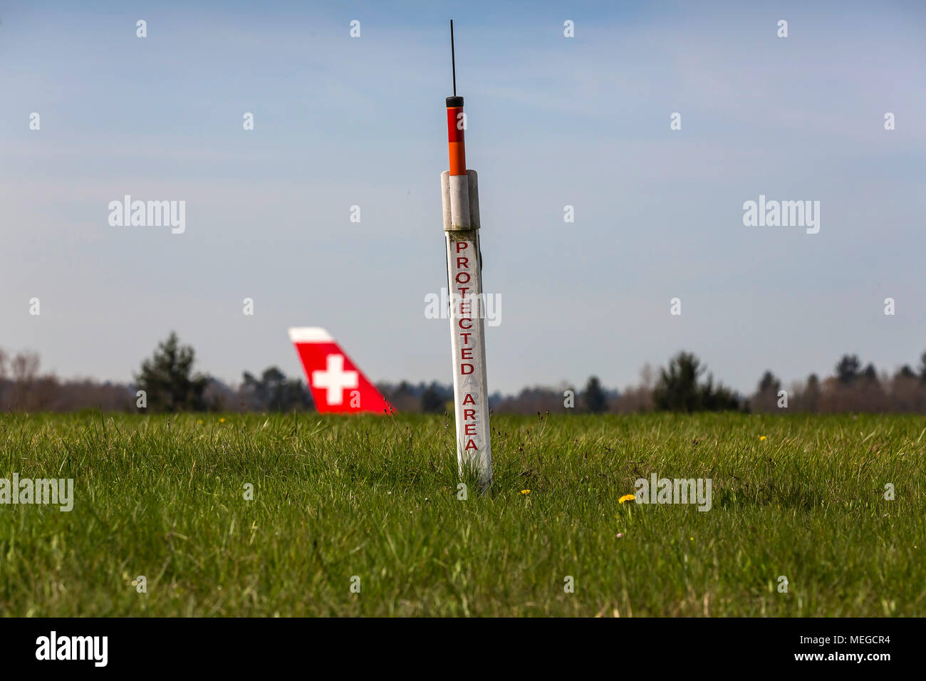 Airport Zuerich ZRH, Airplane taxiing to take-off position, tail fin of a Swiss airplane. Protected Area. Stock Photo