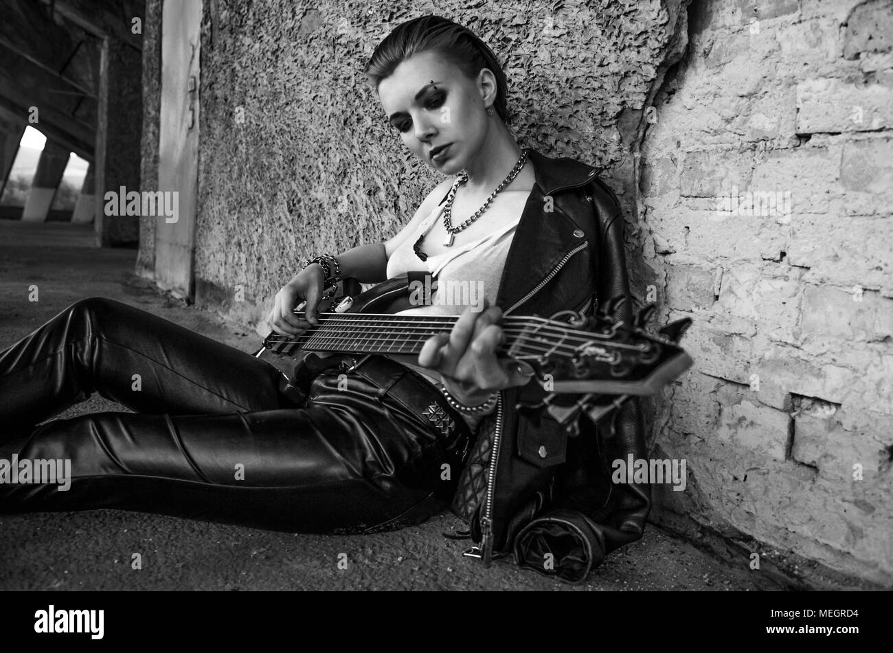 Female rockstar with guitar. Black and white photo . Melancholy Stock Photo