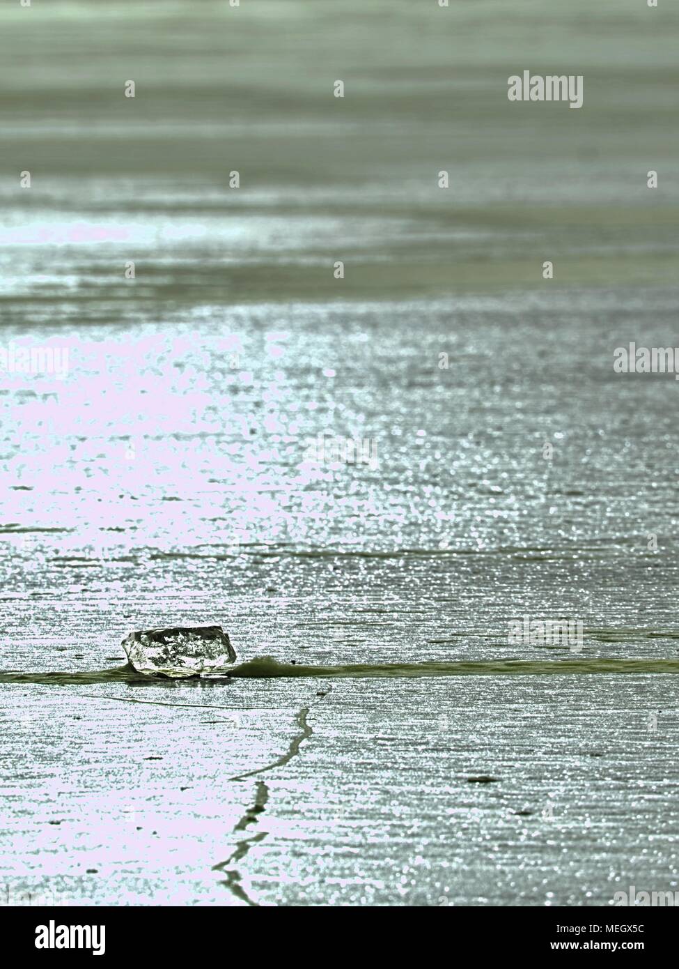 Shards of cracked ice jut out on the frozen lake. The light phenomenon occurs around a very specific time of year Stock Photo