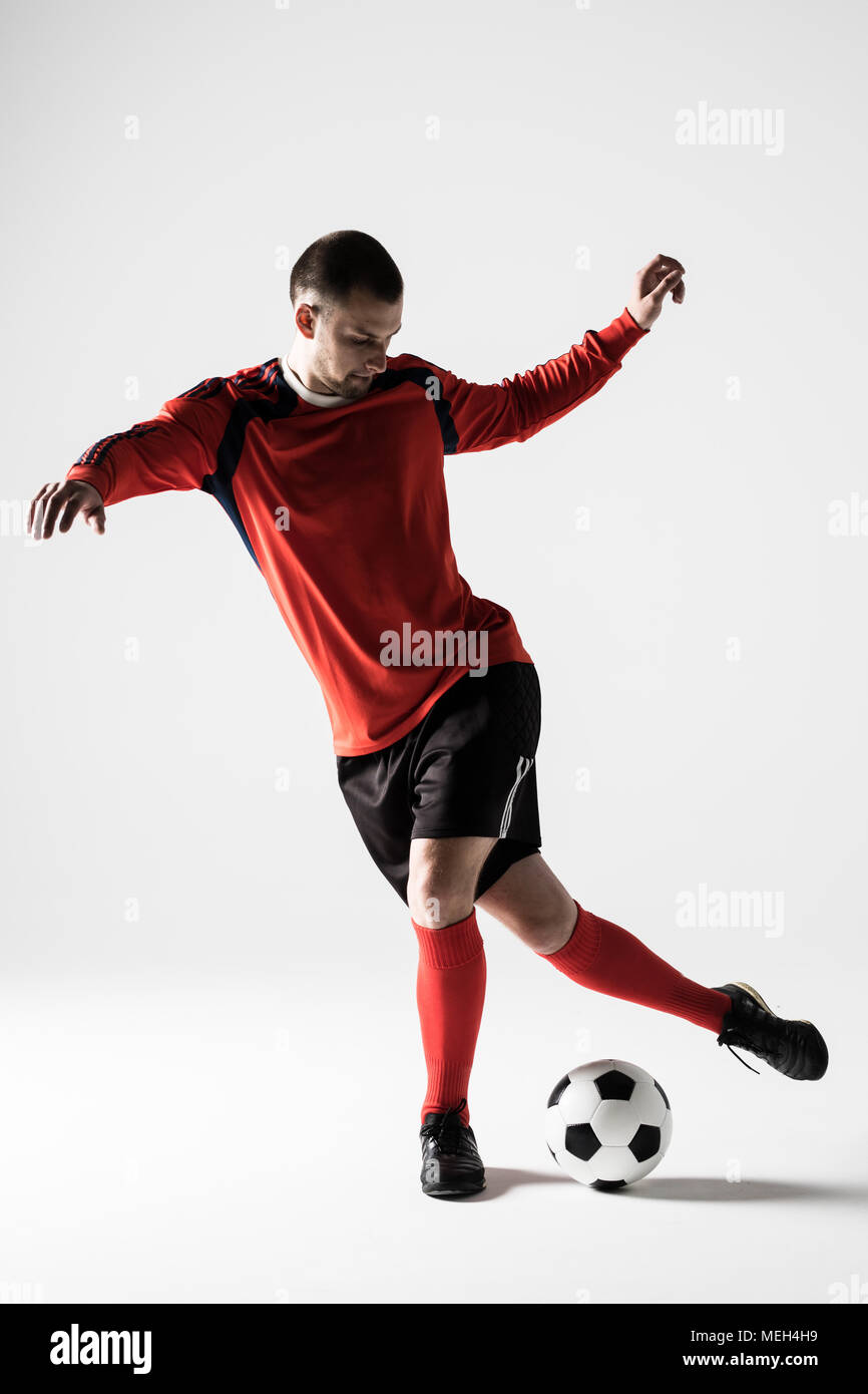 Silhouette of soccer player man playing kicking isolated on white Stock Photo