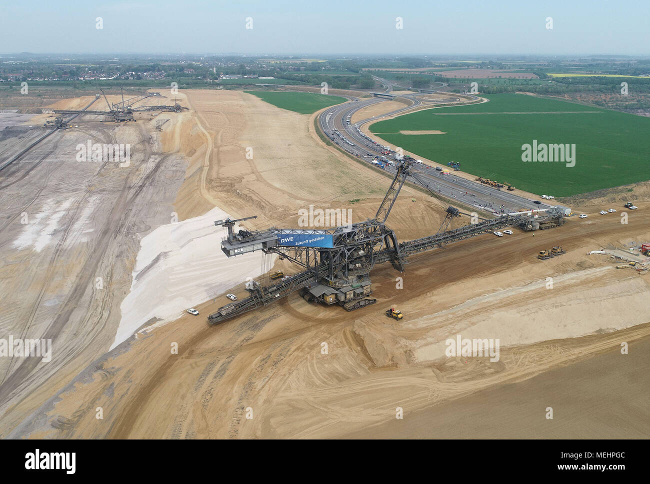 22 April 2018, Germany, Juechen-Hochneukirch: A huge spreader moving from the western section of the Garzweiler surface mine to the eastern Restloch (lit. remaining hole) across the new A44 motorway. The spreader is 48 metres high, 141 metres long and weighs 2,500 tonnes and can manage four to eight metres per minute. (Aerial photograph taken using a drone) Photo: Henning Kaiser/dpa Stock Photo