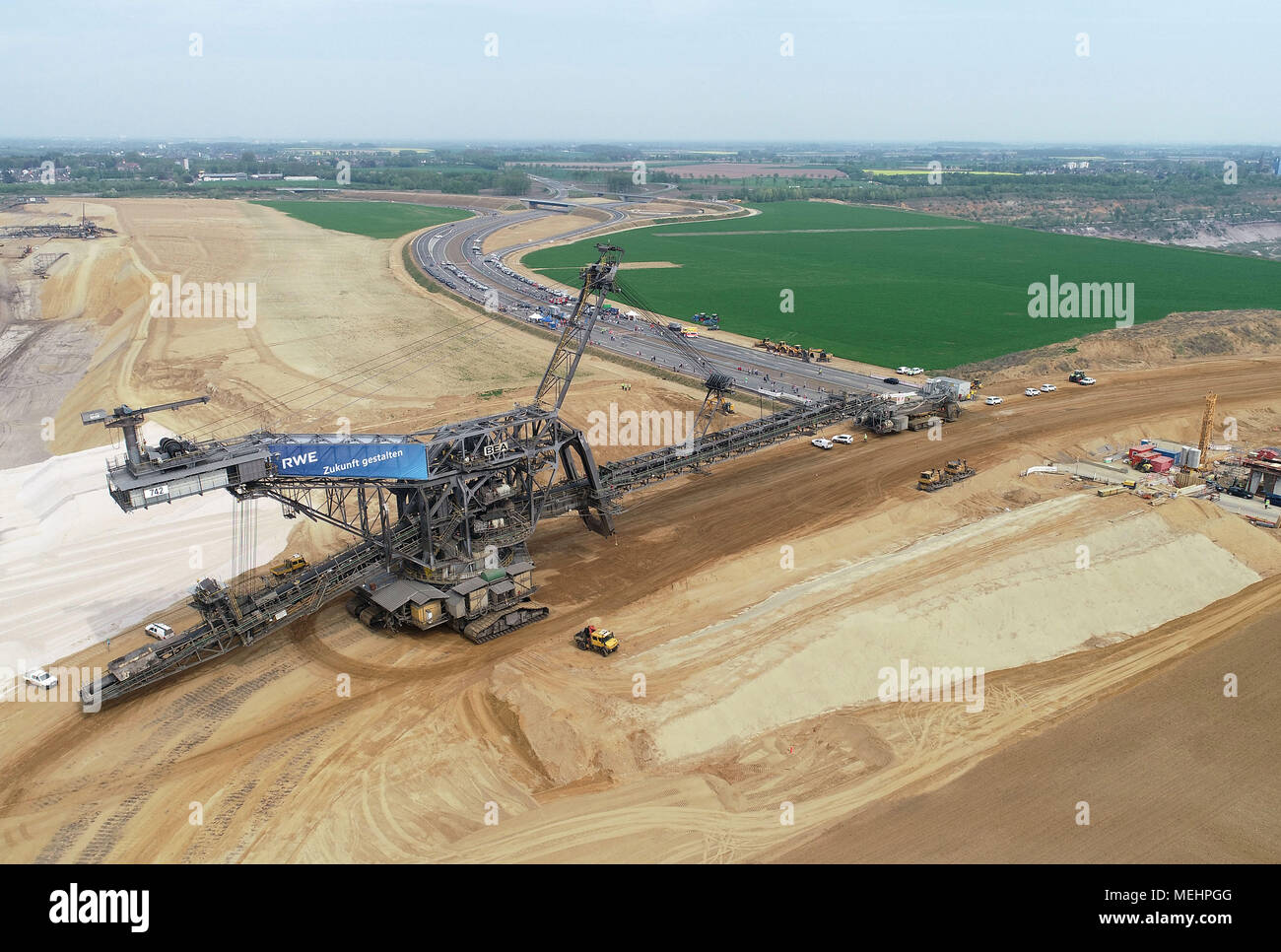 22 April 2018, Germany, Juechen-Hochneukirch: A huge spreader moving from the western section of the Garzweiler surface mine to the eastern Restloch (lit. remaining hole) across the new A44 motorway. The spreader is 48 metres high, 141 metres long and weighs 2,500 tonnes and can manage four to eight metres per minute. (Aerial photograph taken using a drone) Photo: Henning Kaiser/dpa Stock Photo