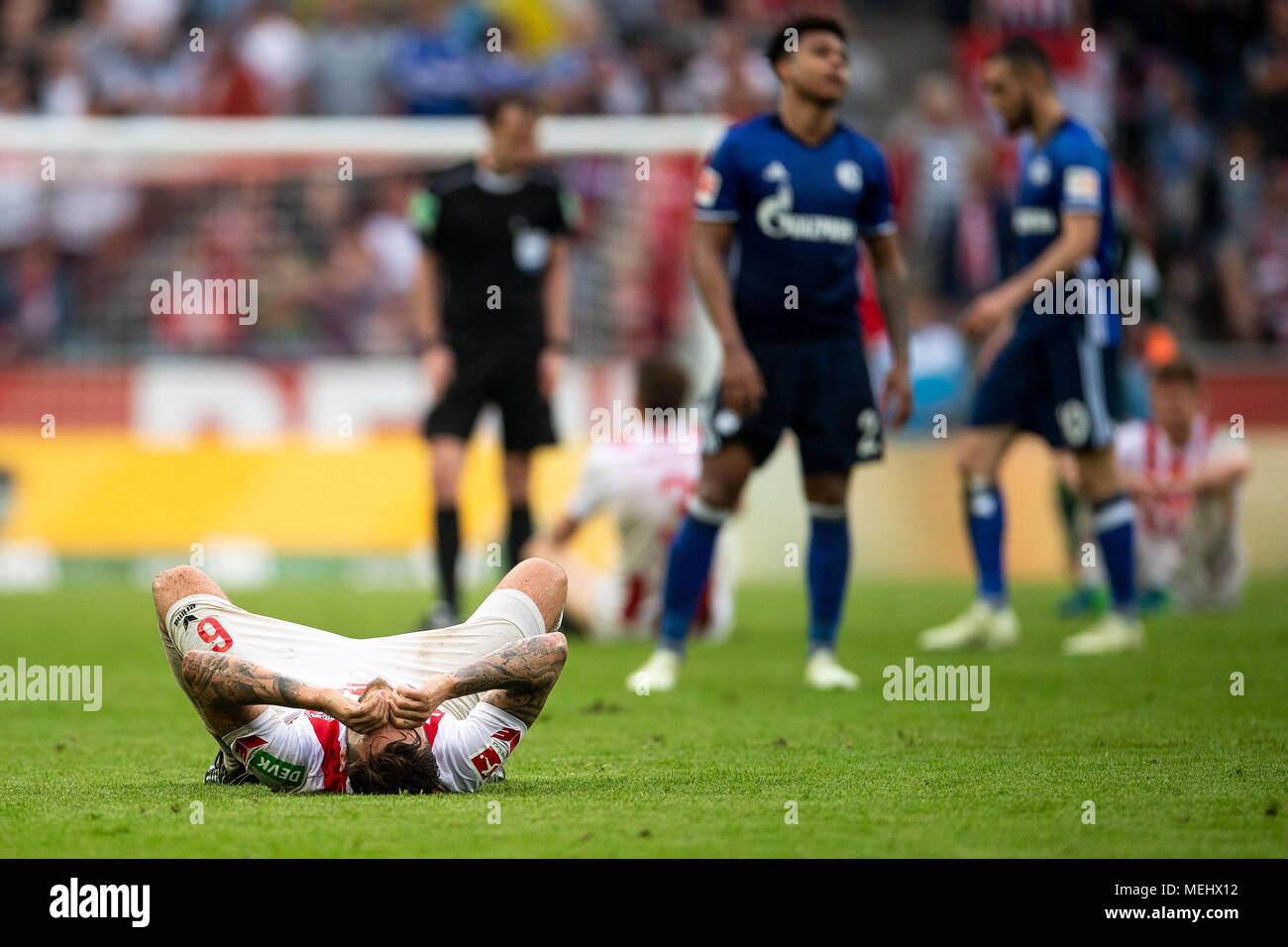 22 April 2018, Germany, Cologne: soccer, Bundesliga, 1. FC Koeln - FC Schalke 04, RheinEnergieStadio. Koeln's Marco Hoeger lying on the grass after the match. Photo: Marius Becker/dpa - IMPORTANT NOTICE: Due to the German Football League·s (DFL) accreditation regulations, publication and redistribution online and in online media is limited during the match to fifteen images per match Stock Photo