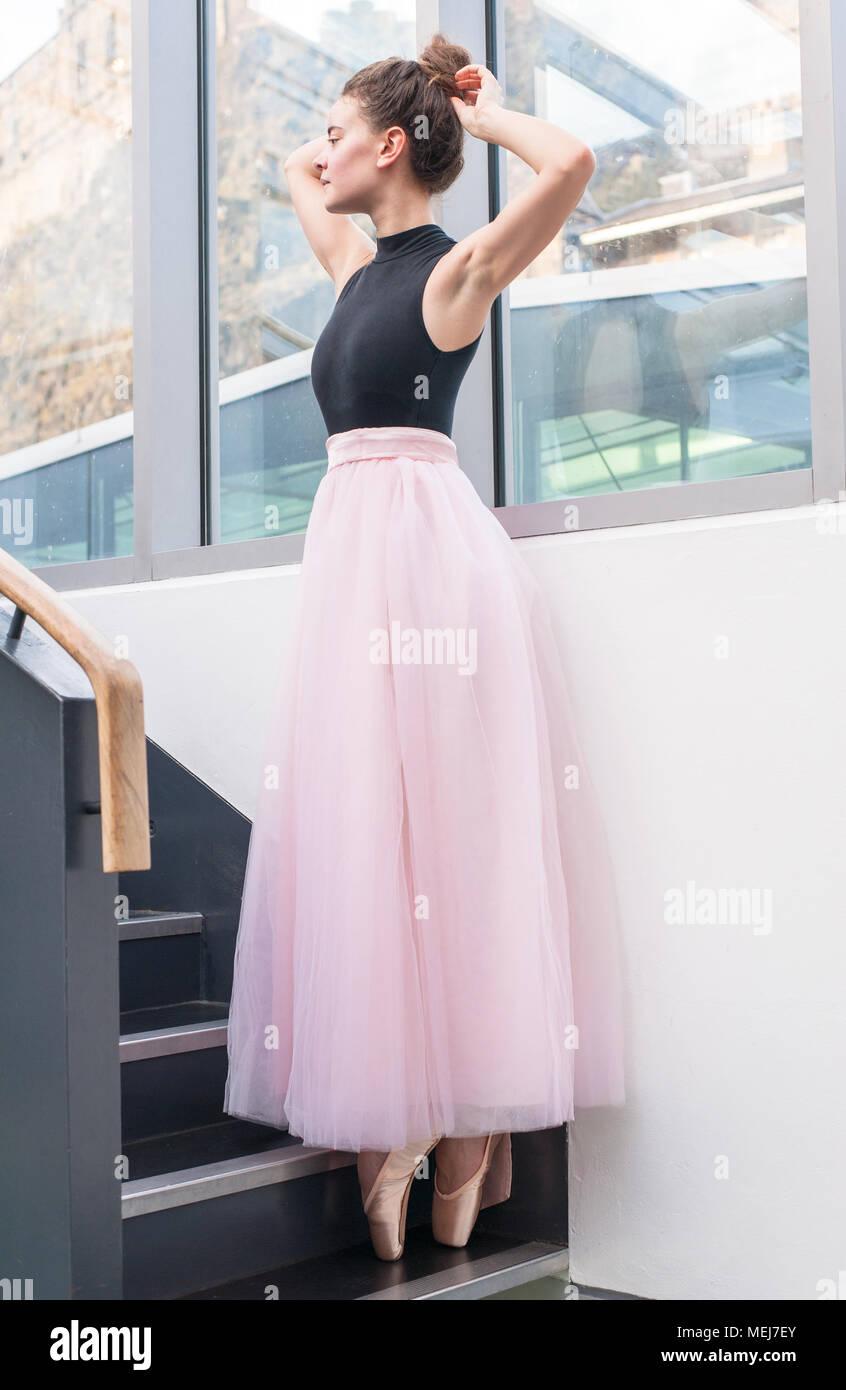 Young ballerina posing in pink tutu and satin pink pointe shoes in a ...