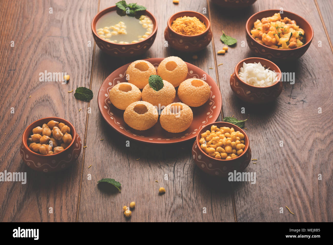 Pani Puri is Indian chat item served in a terracotta bowls and plate which is a popular readside snack from India Stock Photo