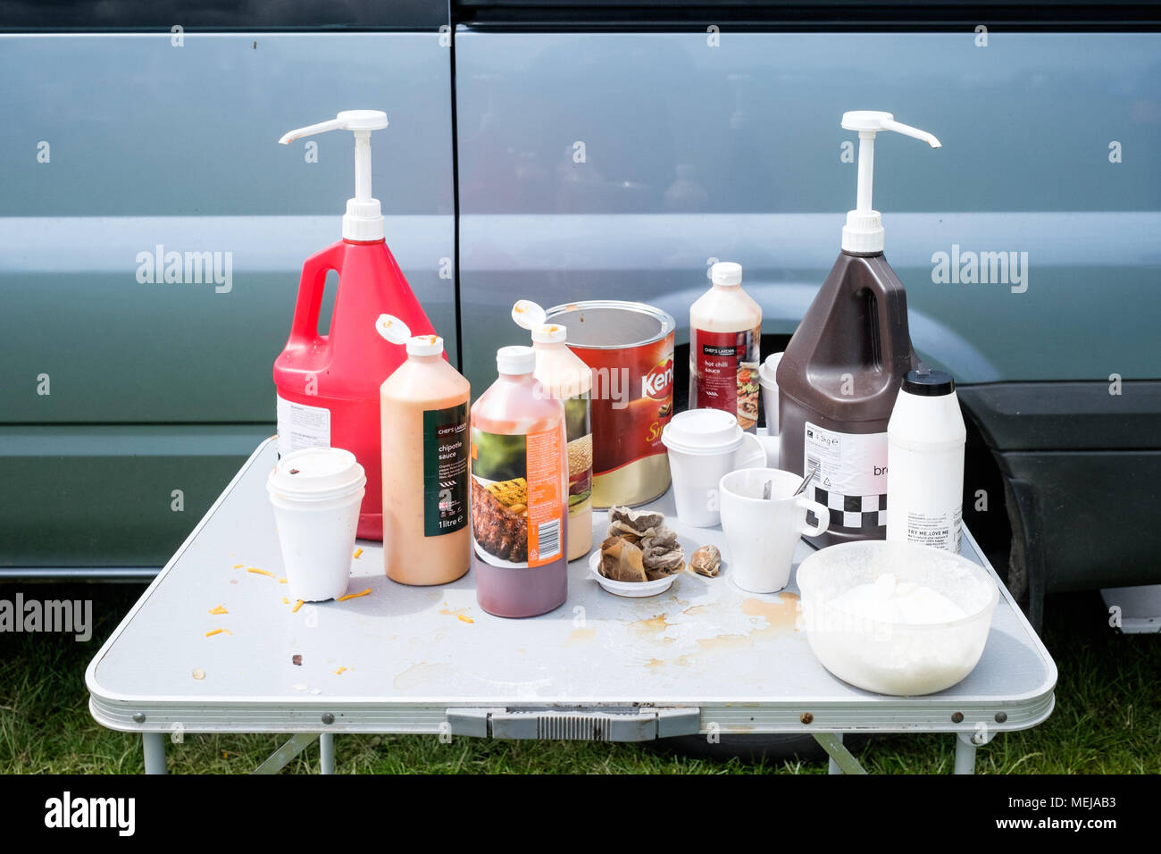 Very British condiments: sauces, used teabags and sugar on a table at a summer horse fair in County Durham England. Stock Photo