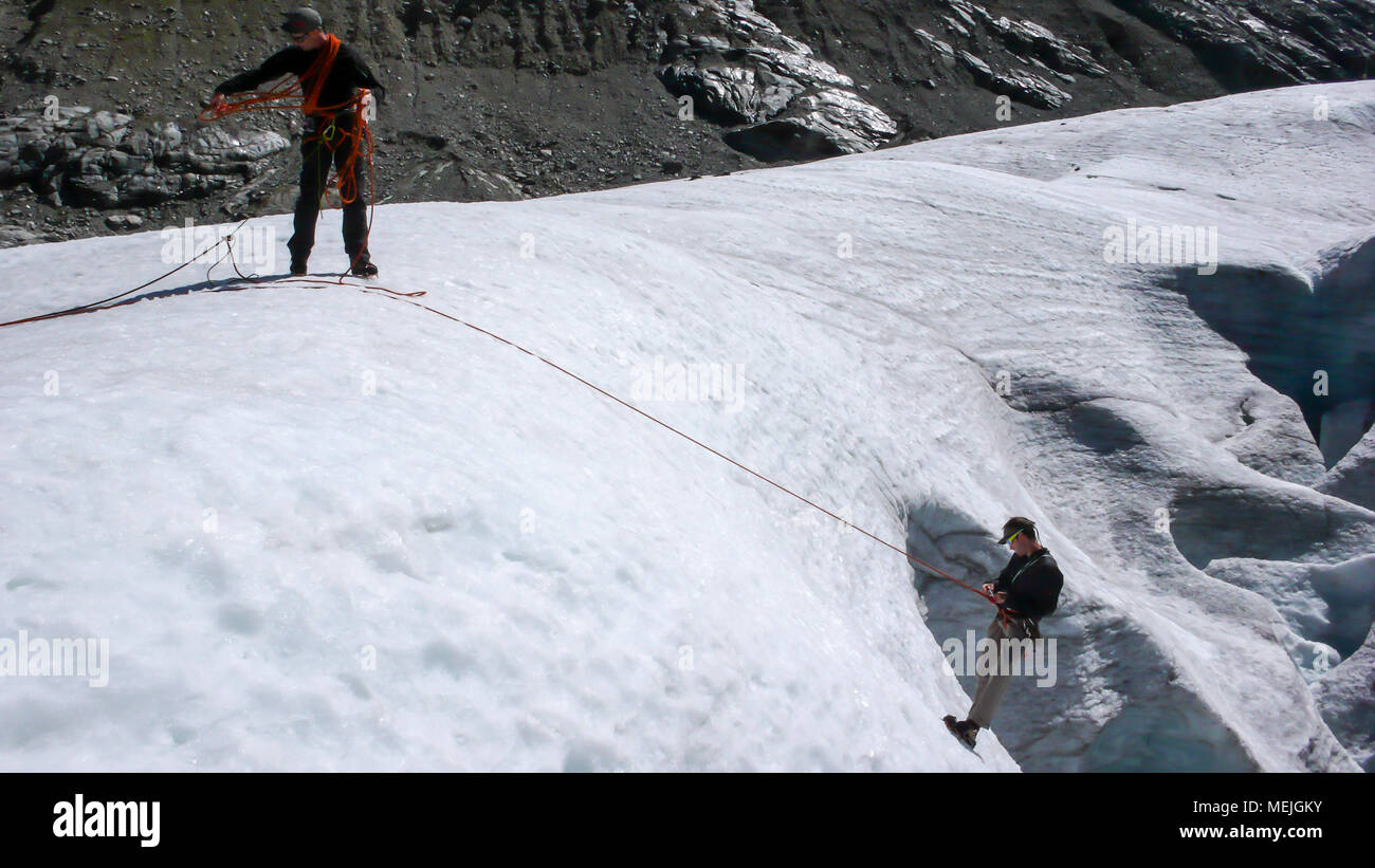 one male mountain guide installing a pulley system for crevasse rescue