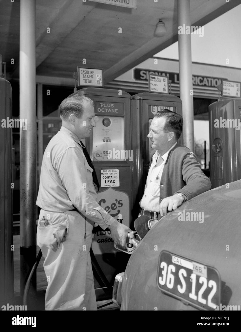 A car owner gets a assistance from a service station attendant in California, ca. 1946. Stock Photo