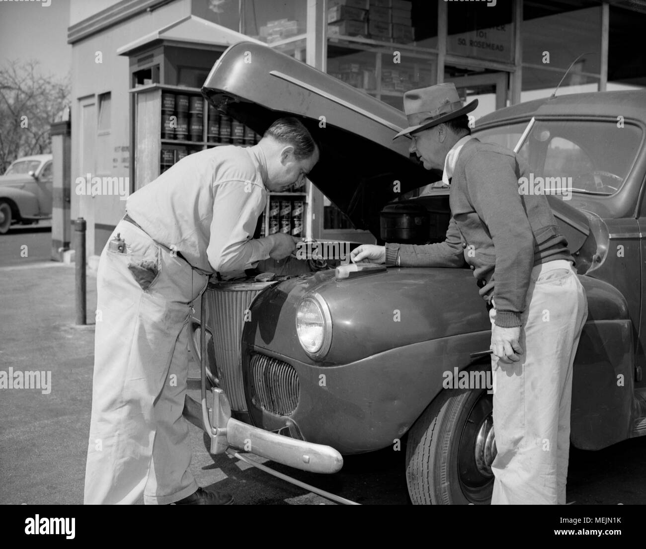 A car owner gets a assistance from a service station attendant in California, ca. 1946. Stock Photo