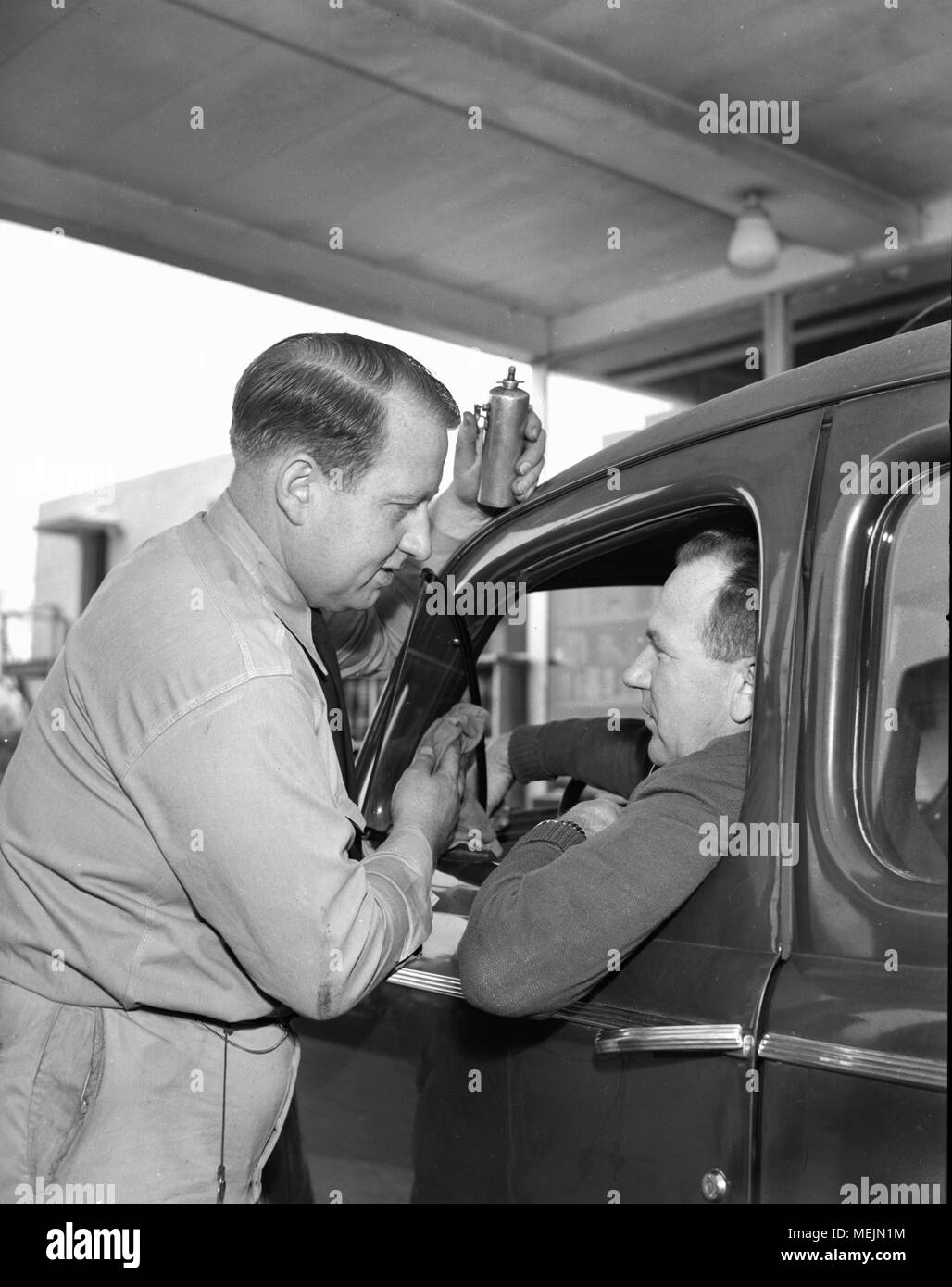 A service station attendant assists a car owner in Southern California, ca. 1946. Stock Photo