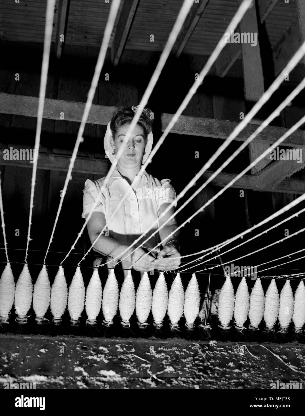 A worker watches an early industrial plastic manufacturing process in a California factory, ca. 1946. Stock Photo