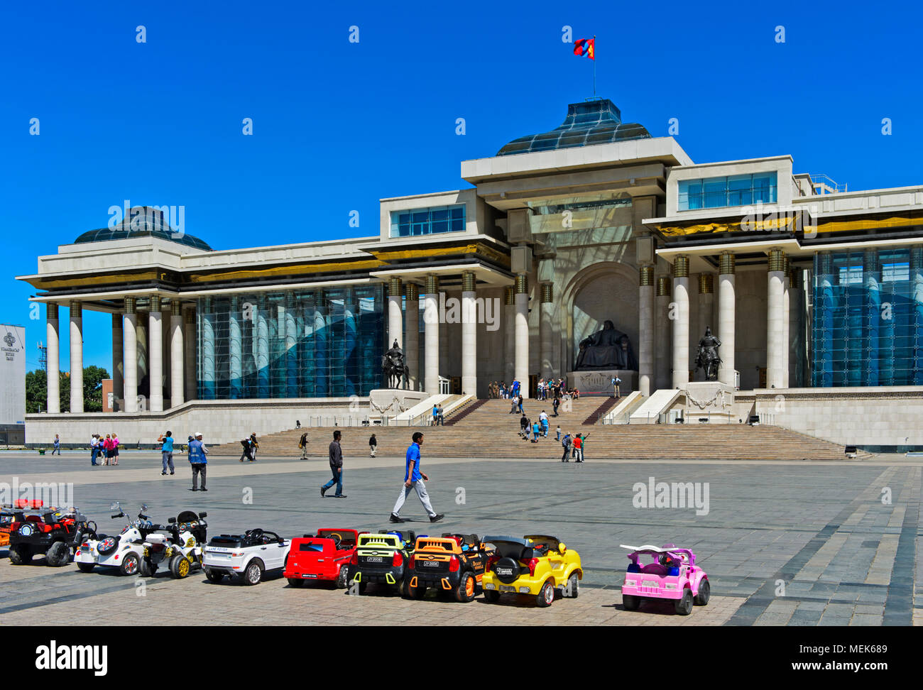Electric toy cars waiting for kids in front of the Parliament Building, Sükhbaatar Square, Ulaanbaatar, Mongolia Stock Photo