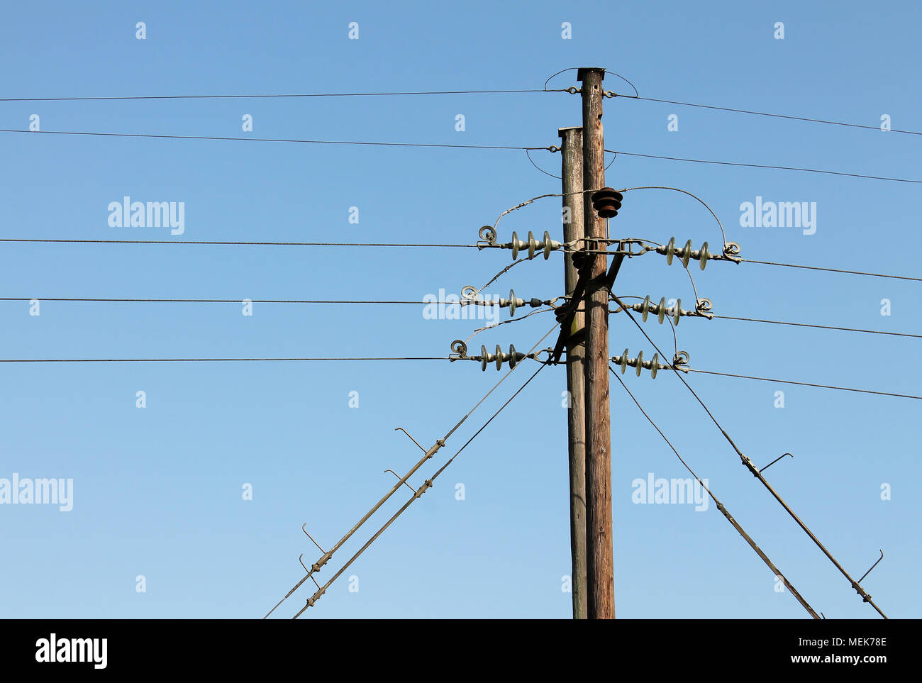 power line supports against a blue sky background Stock Photo - Alamy