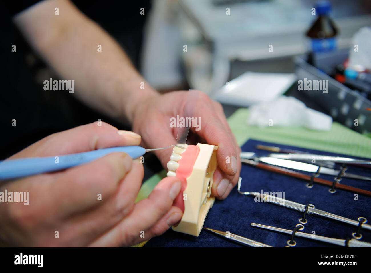 Dental technician manifacturing medical tooth prosthetic in laboratory