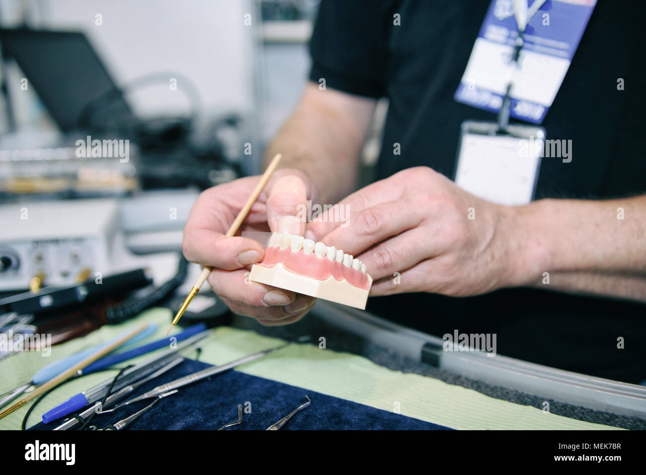 Dental technician manifacturing medical tooth prosthetic in laboratory