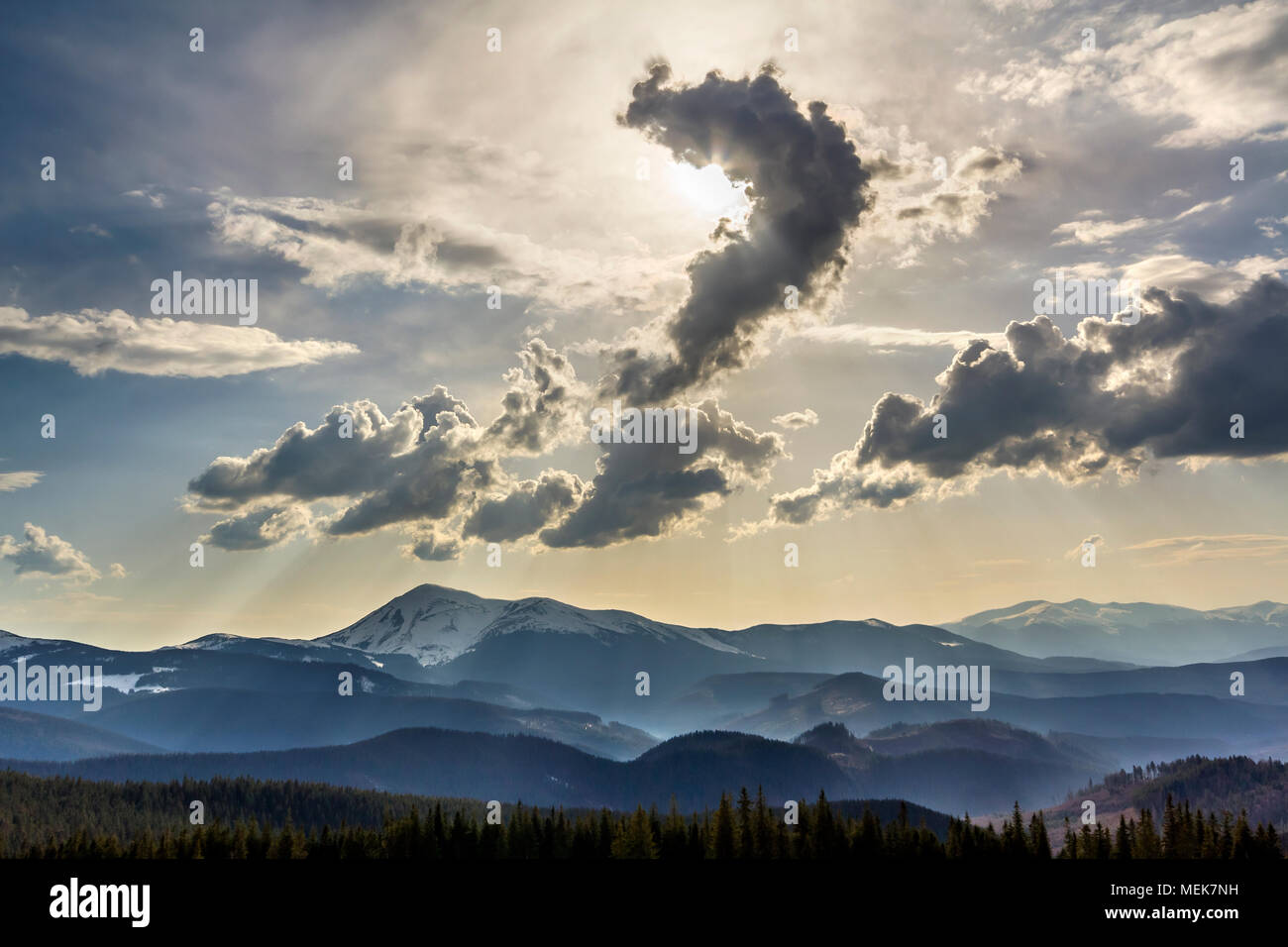 Beautiful fantastic view of blue sky with bright white clouds in mysterious shape of question over magnificent mountain rage with snow covered tops an Stock Photo