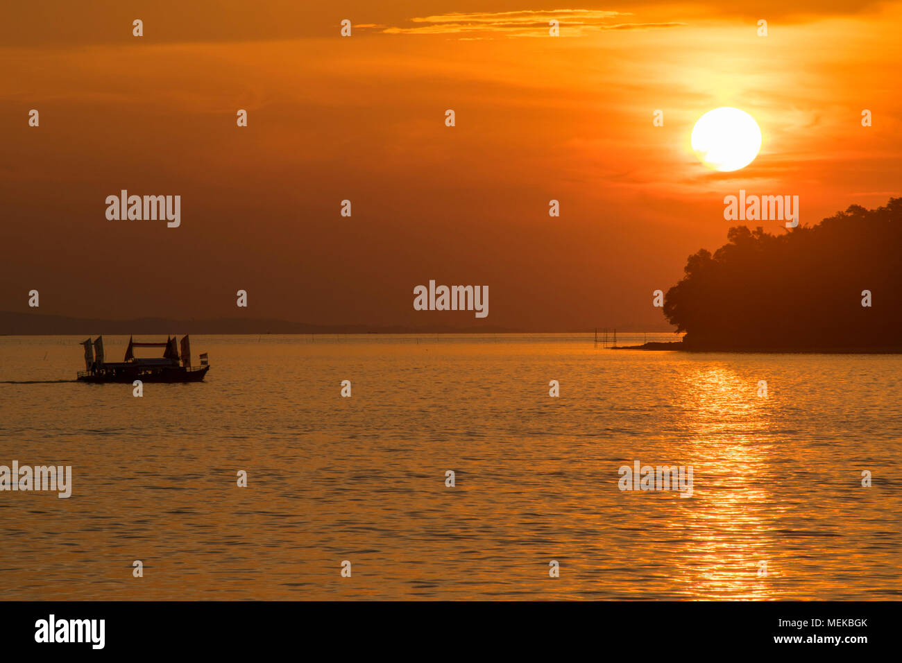 silhouette of nautical vessels against golden hour sunset Stock Photo