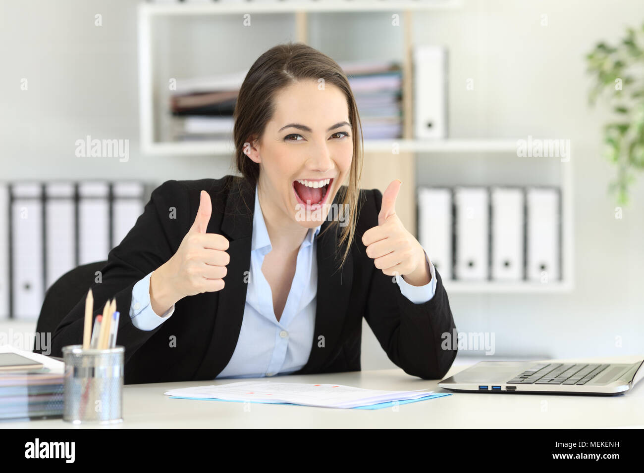 Front view portrait of an excited executive looking at camera with thumbs up at office Stock Photo