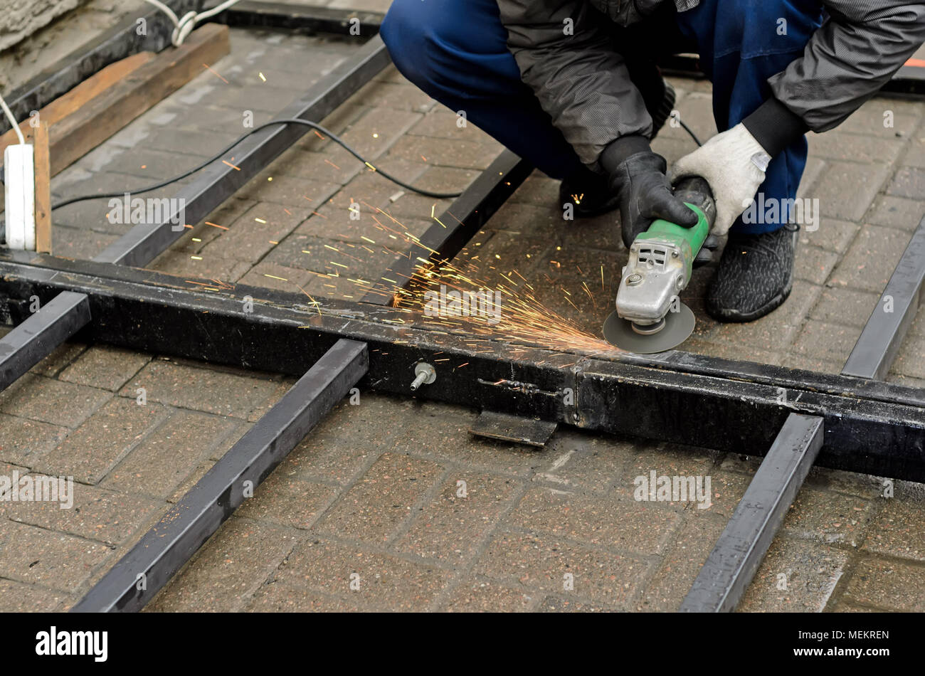 worker in gloves cleans the angle grinder metal construction.Copyspace left Stock Photo